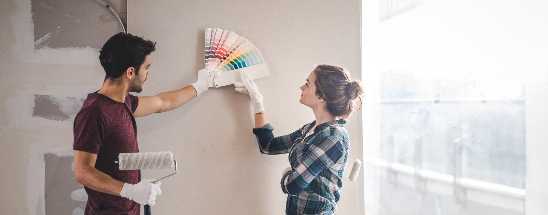 A couple looking at paint samples against a blank wall