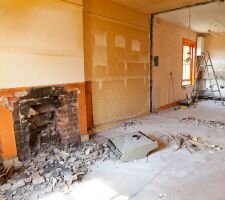 Image of a home during repairs with a fireplace and a ladder